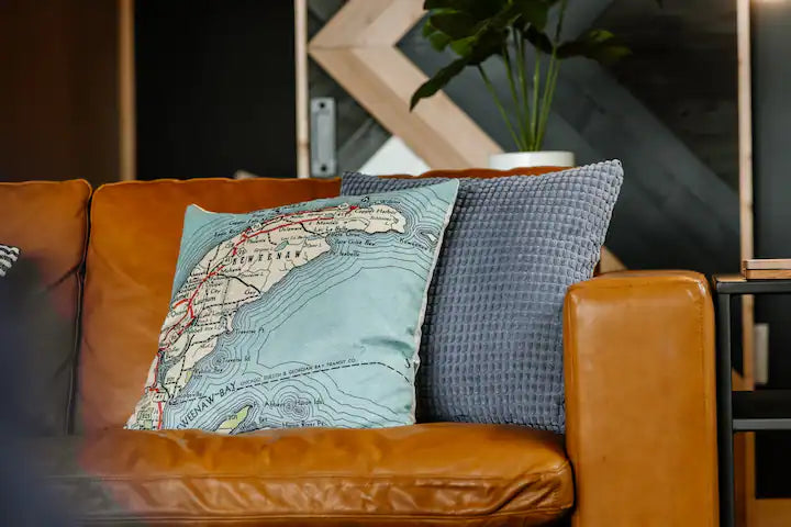 Vintage map pillows on a leather sofa