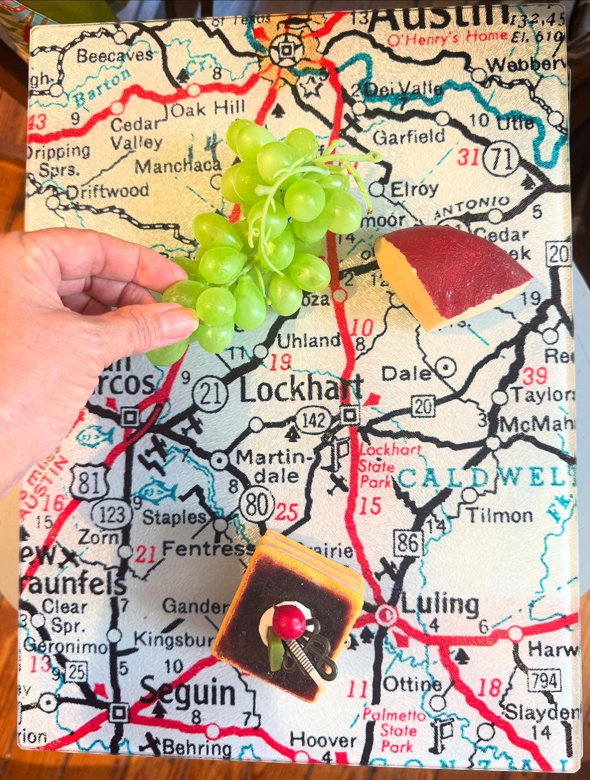 Vintage map glass cutting board served with grapes and cheese