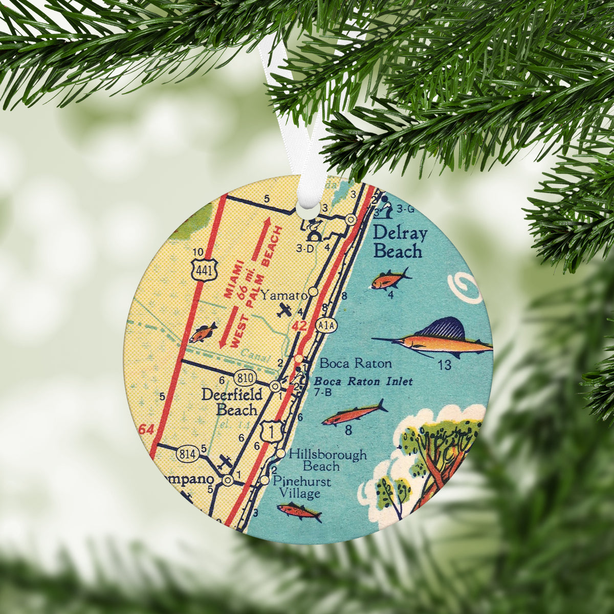 Round Boca Raton Florida vintage map ornament hanging from a white ribbon on evergreen branches with turquoise water illustrated fish and nearby beach towns