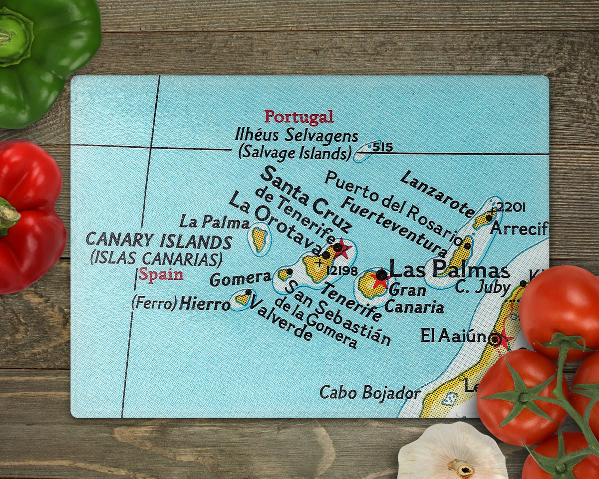 Canary Islands vintage map glass cutting board with turquoise water and yellow islands including Tenerife and Gran Canaria on a wooden surface with vegetables
