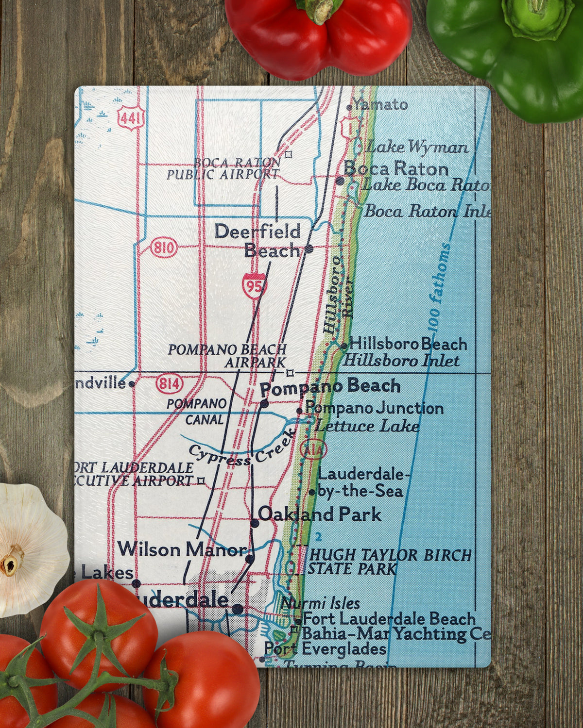 Pompano Beach Florida vintage map glass cutting board shown vertically on wood with vegetables featuring Deerfield Beach Boca Raton and Fort Lauderdale